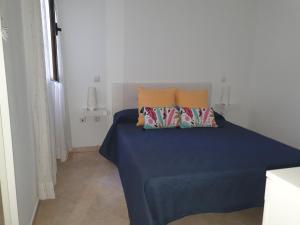 a bedroom with a blue bed with two pillows at Mi Cotillo in Cotillo