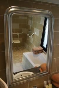 La salle de bains est pourvue d'une baignoire, d'une douche et d'un miroir. dans l'établissement Gîtes " Arromanches" ou "Bord de Mer PMR" 2 chambres en FRONT DE MER à Asnelles , 3km d'Arromanches, 10km de Bayeux, à Asnelles