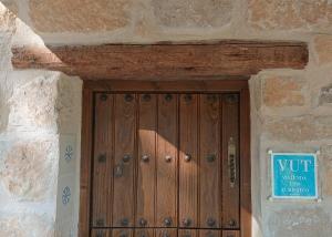 una puerta de madera en un edificio de piedra con un cartel. en Casa El Pinar, en Beceite