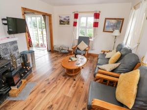 ein Wohnzimmer mit einem Sofa und einem Tisch in der Unterkunft Lough Mask Road Fishing Cottage in Cong