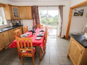 eine Küche mit einem Tisch und einem roten Tischtuch in der Unterkunft Lough Mask Road Fishing Cottage in Cong