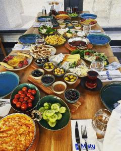 een lange houten tafel met borden met eten erop bij Misty Cave Hotel in Urgup
