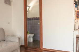 ein Badezimmer mit einem WC, einem Sofa und einem Spiegel in der Unterkunft Attico con terrazza unico in Cagliari