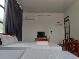 a hotel room with two beds and a tv at PHÚC ANH Hotel 1 in Bản Co