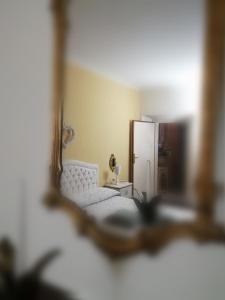 a reflection of a bedroom with a bed and a mirror at La Bouganville e Il Gelsomino in Pietrasanta