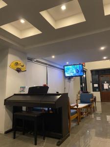 un soggiorno con pianoforte e TV a schermo piatto di 43 Home a Bangkok Noi