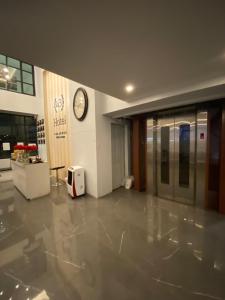 an empty lobby with a clock on the wall and a clock at 43 Home in Bangkok Noi