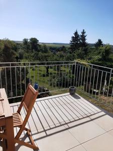 een terras met een stoel, een tafel en een hek bij Gîte LES PAPILLONS in Bining-lès-Rohrbach