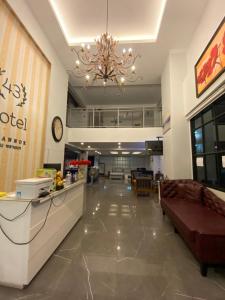 una hall di un hotel con divano e lampadario a braccio di 43 Home a Bangkok Noi