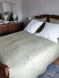 a bedroom with a large white bed and a mirror at Gîte LES PAPILLONS in Bining-lès-Rohrbach