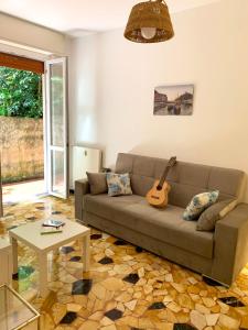 un soggiorno con divano e chitarra di Appartamento al mare a Santa Margherita Ligure