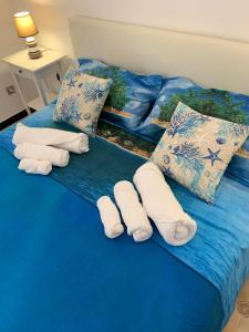 un letto blu con asciugamani e cuscini sopra di Appartamento al mare a Santa Margherita Ligure