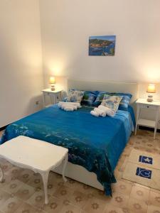 una camera con un letto blu con due tavoli di Appartamento al mare a Santa Margherita Ligure