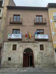 a building with flags on the front of it at Hostel Catedral Burgos in Burgos