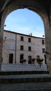 un grand bâtiment en briques avec deux tables devant lui dans l'établissement Casa Vacanza L'Antico Borgo - Moresco, à Moresco