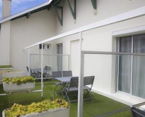 a patio with a table and chairs next to a building at La Pergola d'Arcachon in Arcachon