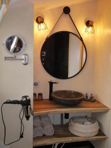 a bathroom with a sink and a mirror on the wall at Le Chapeau Rouge in Lusignan