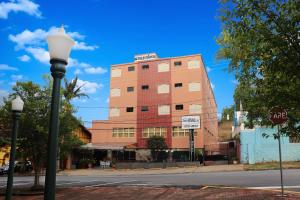 a building on a city street with a street light at HOTEL ESTÂNCIA - ESTACIONAMENTO GRATUITO ROTATIVO - Vagas Limitadas in Poços de Caldas