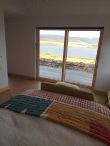 a bedroom with a large window with a view of the ocean at Treaslane Stable Rooms in Skeabost