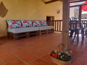 a couch on a porch with a table and chairs at Casa São Simão in Barcelos