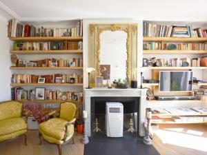 un soggiorno con camino e librerie di St Germain Luxury a Parigi