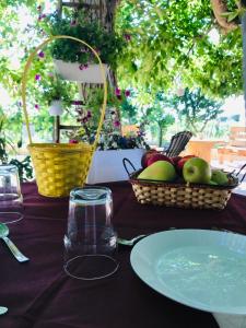 a table with a plate of apples and a basket of fruit at Tenuta Vigna del Noce in Corato