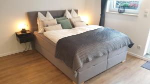 a bedroom with a large bed with white sheets and pillows at Apartment Airport Cologne in Cologne