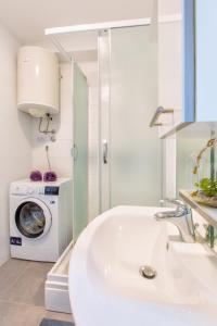 uma casa de banho com um lavatório e uma máquina de lavar roupa em Summer stone pleasure em Split