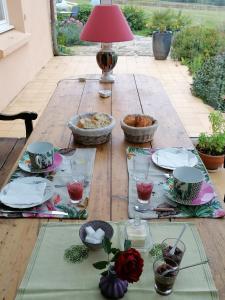 a wooden table with plates and bowls of food on it at La Tour du Bois Dormant in Plozévet