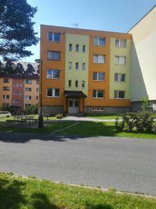 un bâtiment avec un parking en face de celui-ci dans l'établissement Apartmán Tatranská Lomnica, à Tatranská Lomnica