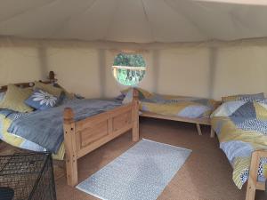 En eller flere senge i et værelse på Cae Mawr Yurt Off-Grid Glamping