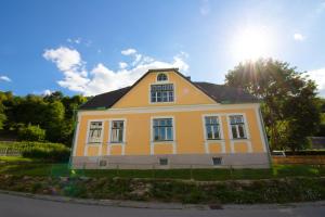 Una casa amarilla y blanca con el sol detrás. en Villa Hardegg, en Hardegg