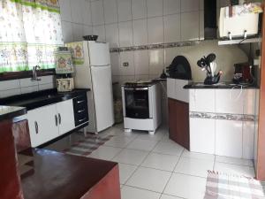 cocina pequeña con nevera y fogones en Casa em São Francisco Xavier/sp en São Francisco Xavier