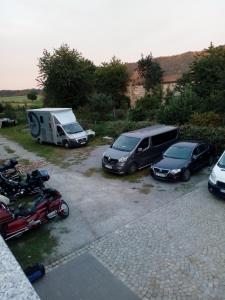 a group of cars parked in a parking lot with a trailer at U Bronka w Książęcym Lesie in Niedaszów