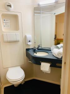 een badkamer met een toilet en een wastafel met een spiegel bij Hotel Inn Design Dijon Sud in Marsannay-la-Côte