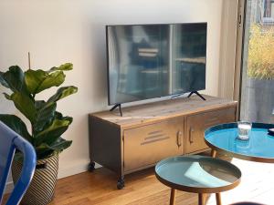 a living room with a television on a dresser at Appartement vue beffroi in Amiens +4 photos