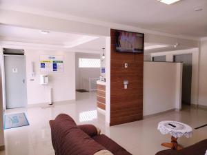 a living room with a couch and a tv at Pousada Boa Vista in Cachoeira Paulista