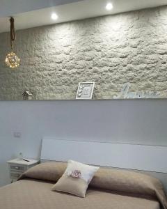 sypialnia z łóżkiem z białą ceglaną ścianą w obiekcie Relais DiVi w mieście Castellammare di Stabia