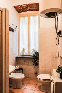 La salle de bains est pourvue de 2 toilettes et d'une fenêtre. dans l'établissement Via Argelati - Navigli Top Location 2, à Milan