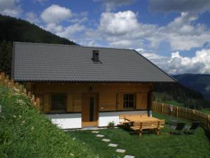 a wooden house with a picnic table in front of it at Chalet Niederhaushof in Ultimo