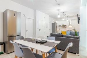 a kitchen and living room with a table and chairs at Flatguest Paez Suites in Las Palmas de Gran Canaria