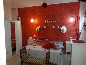 a bedroom with a bed with red walls at Suites Rome in Pescara