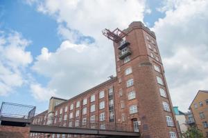 a tall brick building with a balcony on top of it at ChocoLets - The Foss Suite in York