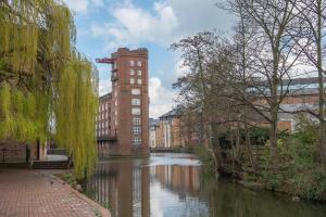 a building next to a river in front of a building at ChocoLets - The Foss Suite in York