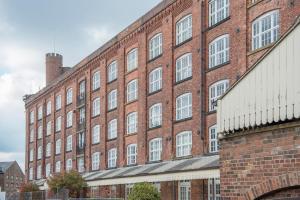 a large red brick building with white windows at ChocoLets - The Foss Suite in York