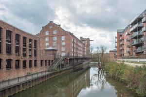 a river in a city with buildings and a bridge at ChocoLets - The Foss Suite in York