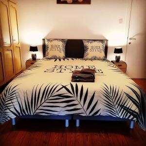 a bedroom with a bed with a black and white comforter at Au fil de l'eau in Grupont