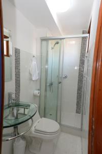 a bathroom with a toilet and a glass shower at Hotel Esmeralda in Iquique