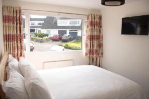 a bedroom with a bed and a large window at Hillgarth Holiday House in Kendal