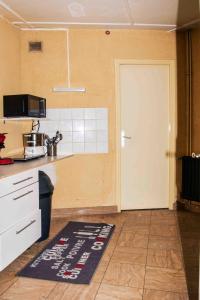 a kitchen with a white door and a kitchen rug at Une balade à la plage in Dunkerque